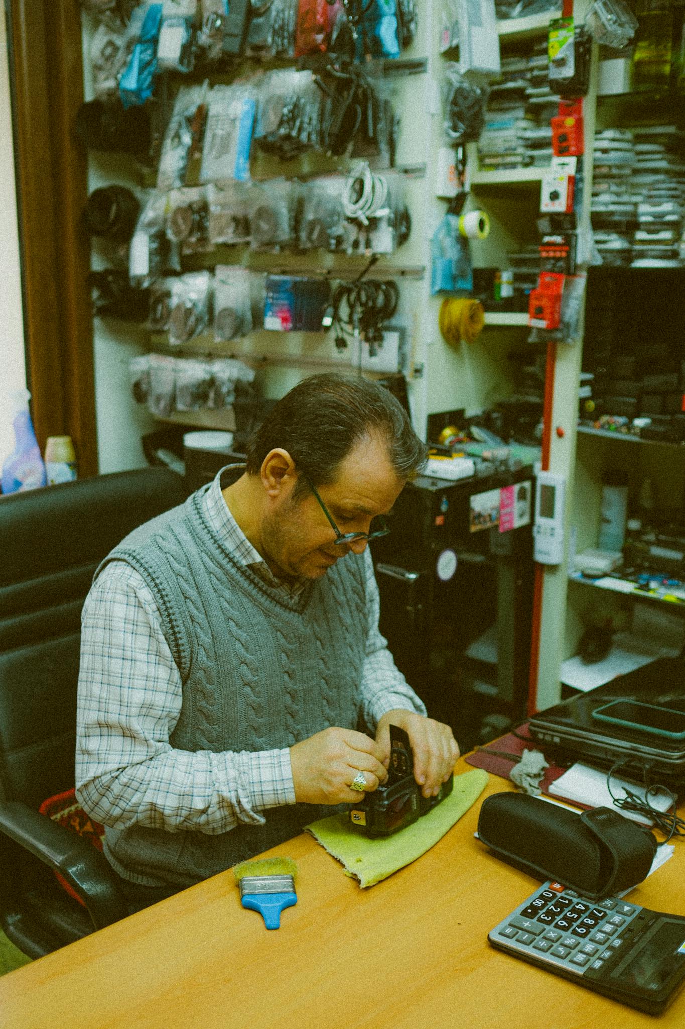 A shoemaker intently crafts in a cozy Istanbul workshop surrounded by tools and materials.