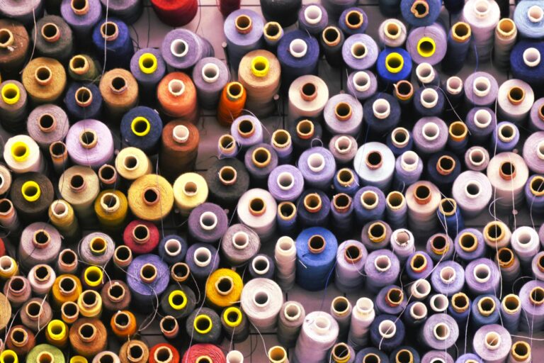 Vibrant collection of multi-colored threads and spools for sewing enthusiasts. Perfect for crafting projects.