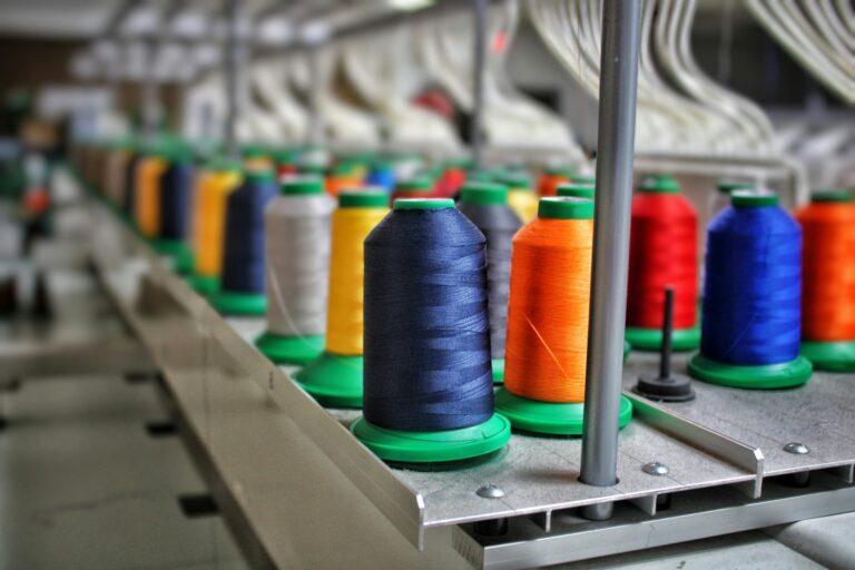 Vibrant spools of thread in a textile factory highlight industrial stitching processes.