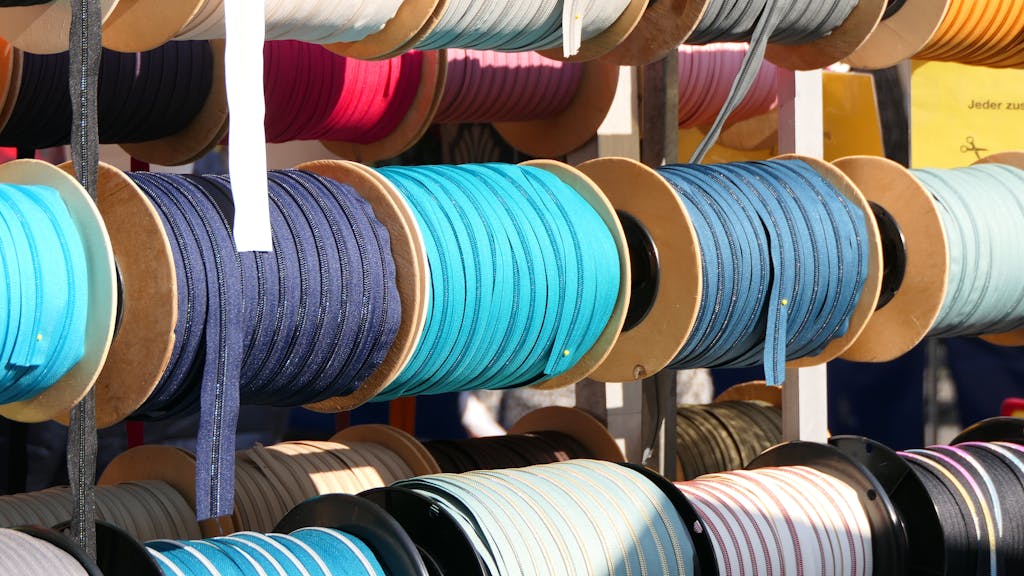 Vibrant spools of textile ribbon on display at Mayen market in Germany.