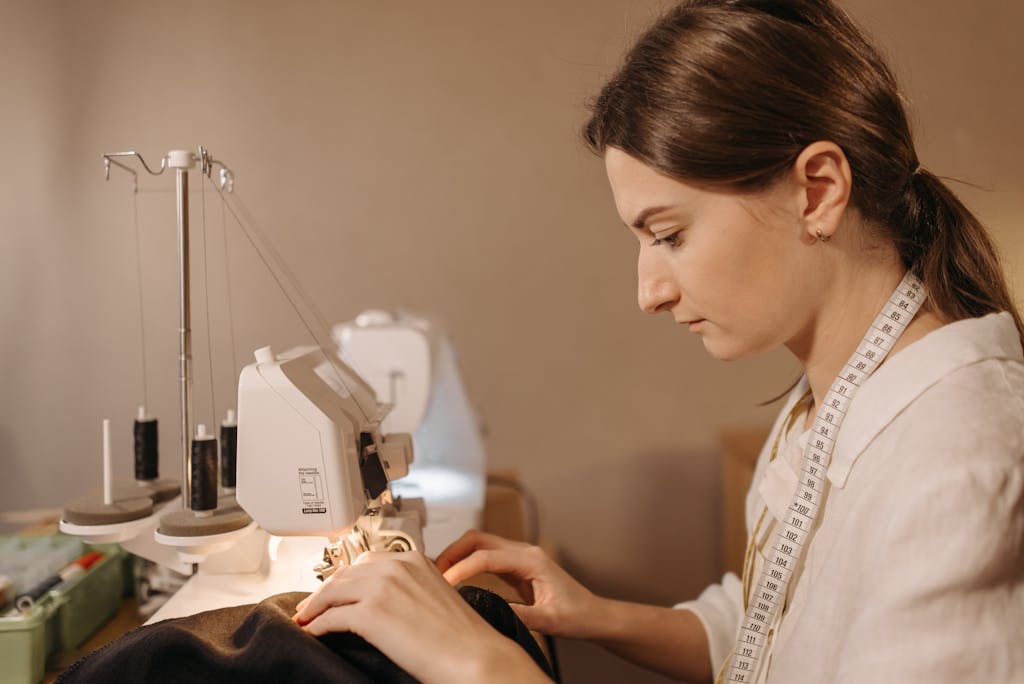 A young woman using a sewing machine, emphasizing craftsmanship in tailoring.